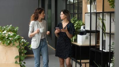 two women walking in an office